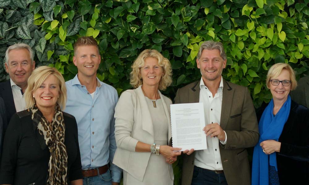 Jacco Vooijs (tweede van rechts) biedt de visie glastuinbouw van LTO Glaskracht aan burgemeester Agnes van Ardenne – van der Hoeven aan.